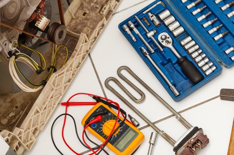 Engineer repairing a washing machine in Chiswick